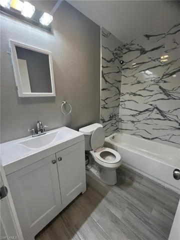 Full bathroom with toilet, shower / bathing tub combination, and vanity