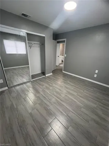 Unfurnished bedroom featuring a closet and hardwood / wood-style flooring