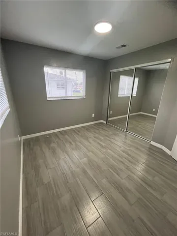 Unfurnished bedroom with a closet and wood-type flooring