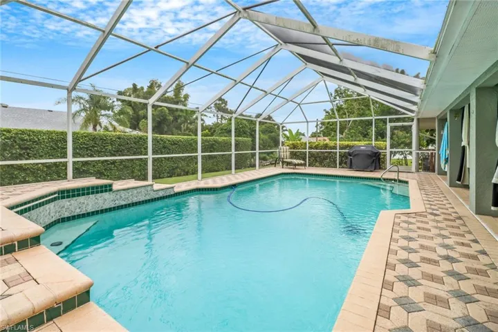 View of pool featuring grilling area and a lanai