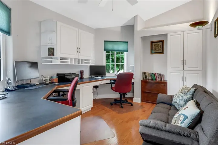 Home office with vaulted ceiling, light hardwood / wood-style flooring, and ceiling fan