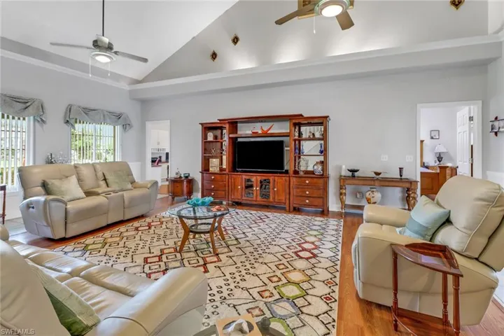 Living room featuring light hardwood / wood-style floors, ceiling fan, and high vaulted ceiling