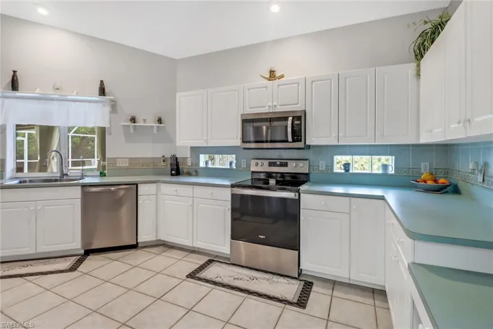 Kitchen with sink, white cabinets, and stainless steel appliances