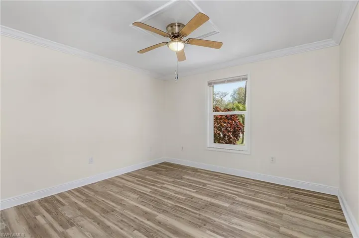 BR 1 with ceiling fan, crown molding, baseboards, and wood finished floors