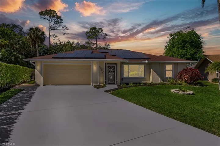 Ranch-style house featuring driveway, a lawn, an attached garage, and stucco siding