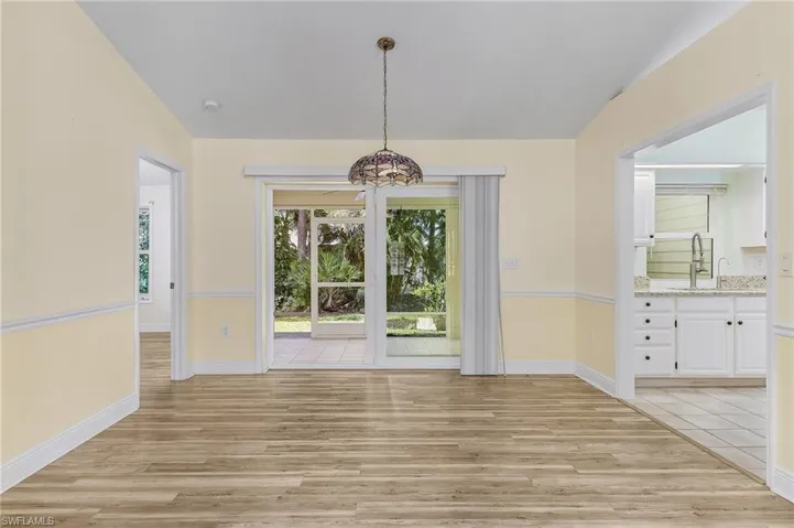 Unfurnished dining area with light wood-style floors, a sink, and baseboards