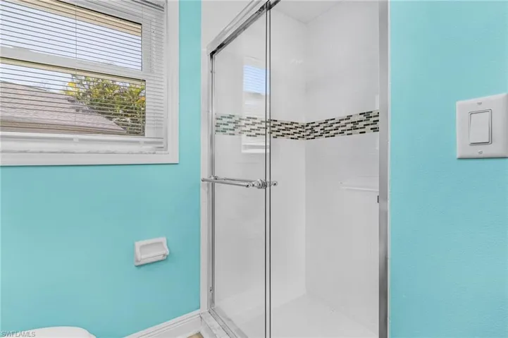 Primary Bathroom featuring a stall shower and toilet