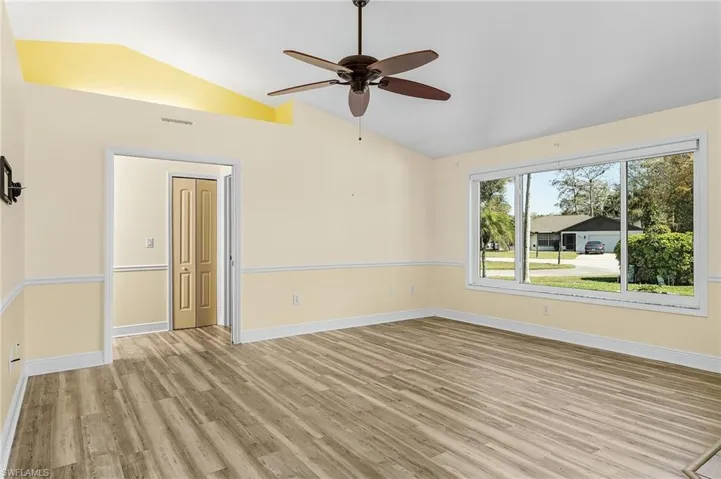 Unfurnished great room featuring light wood-style floors, visible vents, vaulted ceiling, and baseboards