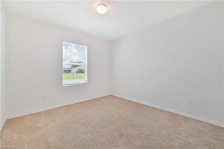 Carpeted empty room featuring baseboards