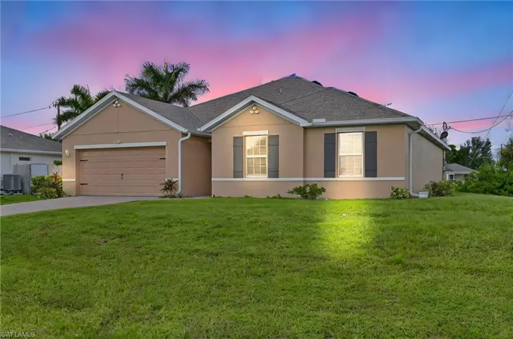 Ranch-style house with an attached garage, stucco siding, a yard, and concrete driveway