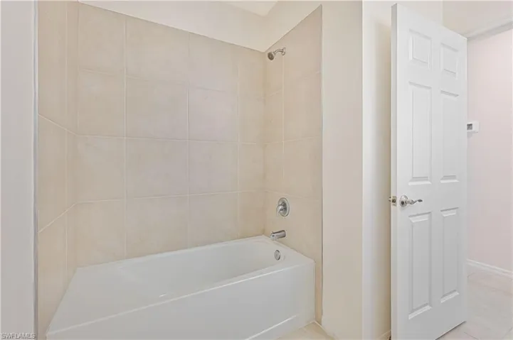 Full bathroom featuring tub / shower combination and tile patterned flooring