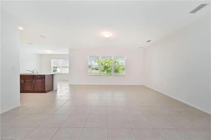 Unfurnished living room with light tile patterned floors and baseboards