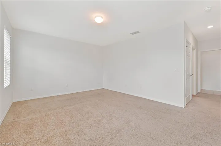 Unfurnished room with light carpet and baseboards