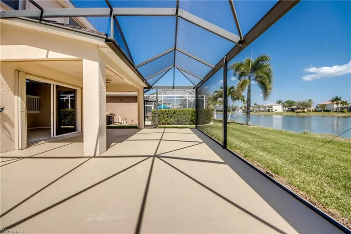 View of patio / terrace featuring a sunroom, glass enclosure, and a water view