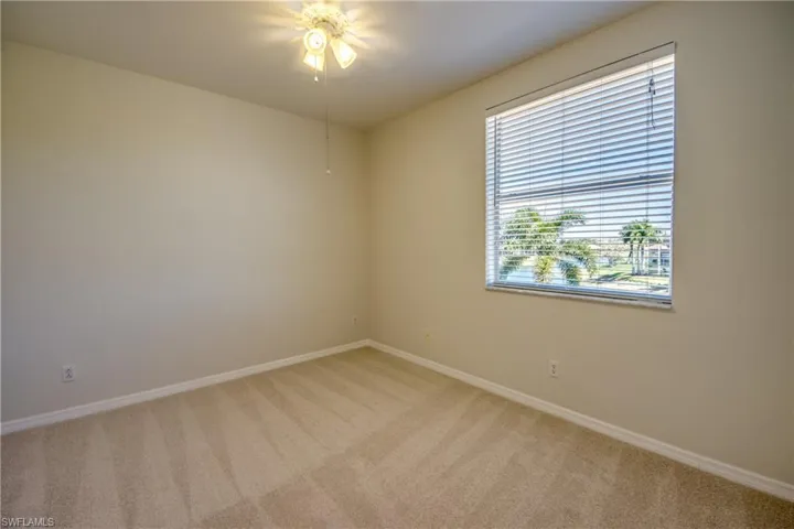 Unfurnished room featuring light colored carpet and a ceiling fan