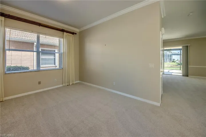 Spare room with ornamental molding and light carpet