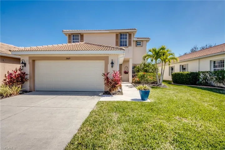 Mediterranean / spanish-style home with a garage, stucco siding, driveway, and a front lawn