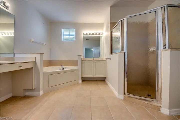 Full bathroom with a shower stall, a bath, vanity, and light tile patterned flooring