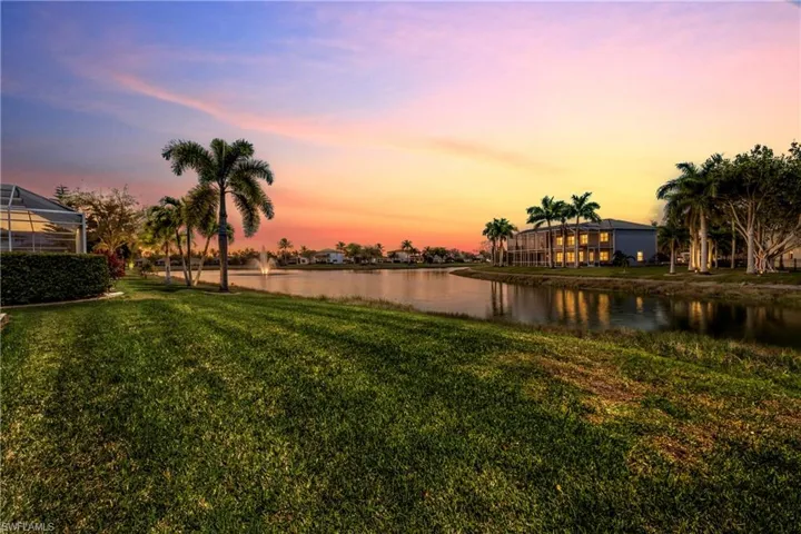 Yard at dusk featuring a water view and a yard