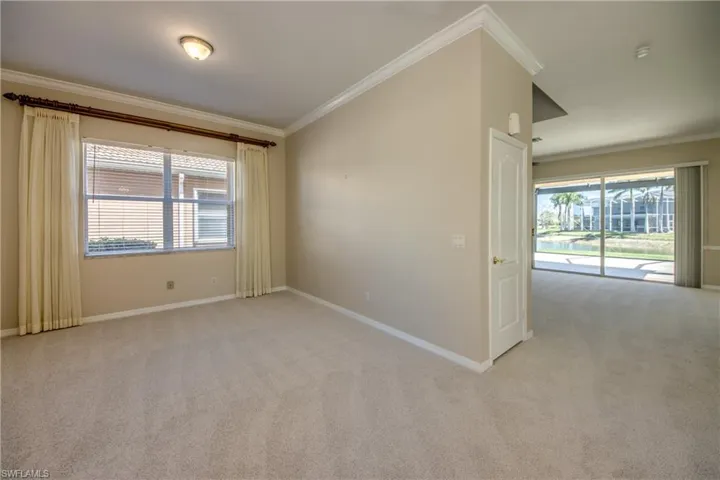 Spare room with crown molding, light carpet, and healthy amount of natural light