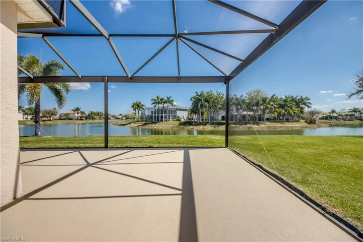 View of patio featuring a sunroom, a water view, and glass enclosure