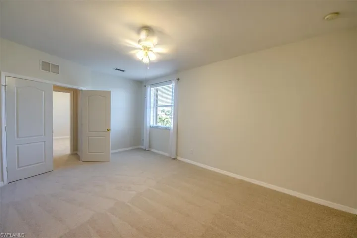 Unfurnished bedroom featuring light carpet and ceiling fan