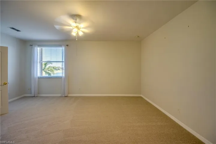 Unfurnished room with light carpet and ceiling fan