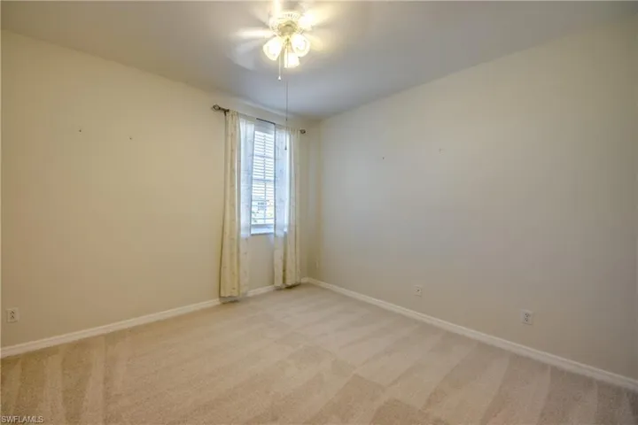 Spare room with light colored carpet and a ceiling fan