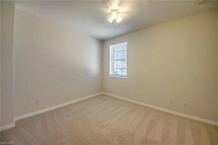 Spare room featuring light carpet and a ceiling fan