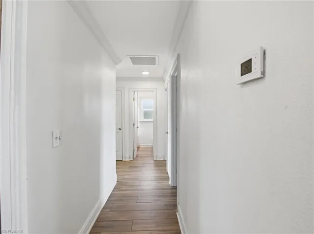 Hall featuring baseboards and dark wood-type flooring