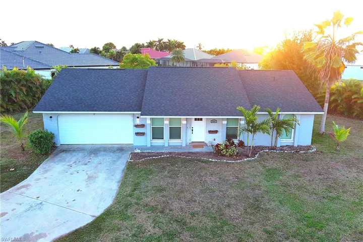 View of front of house featuring driveway, stucco siding, and a shingled roof
