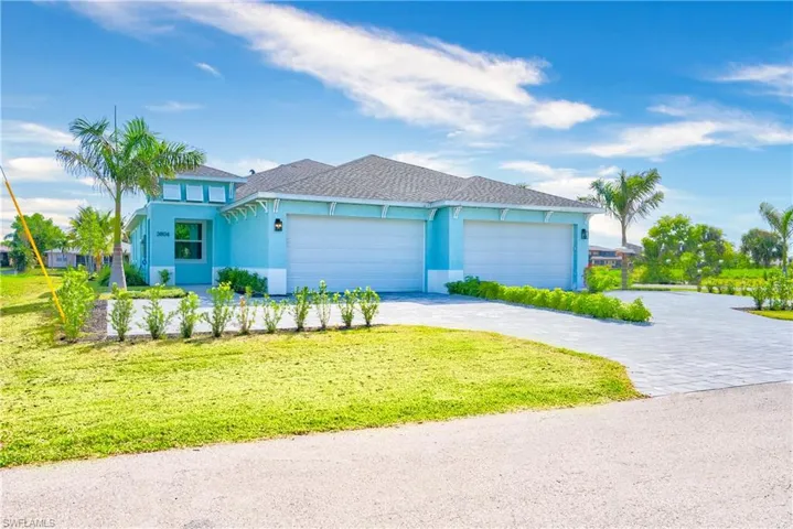 View of front of home with decorative driveway, stucco siding, an attached garage, a shingled roof, and a front lawn