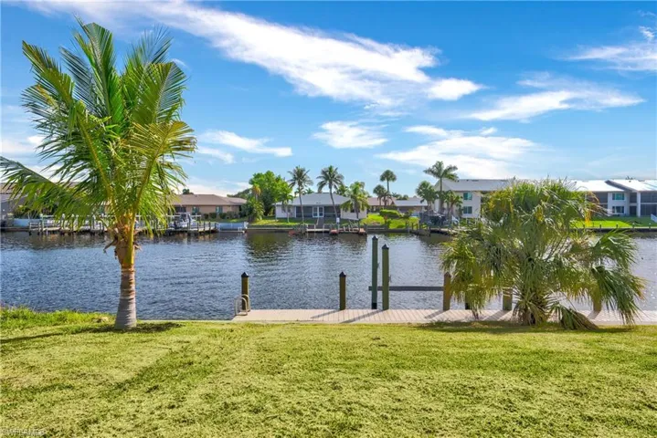 Water view with a boat dock and nearby suburban area