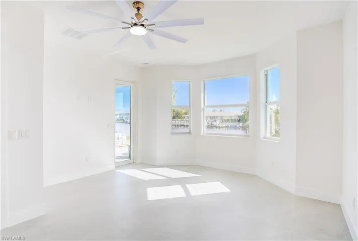 Spare room with ceiling fan and baseboards