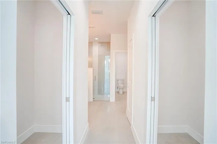 Hallway with light tile patterned floors and recessed lighting