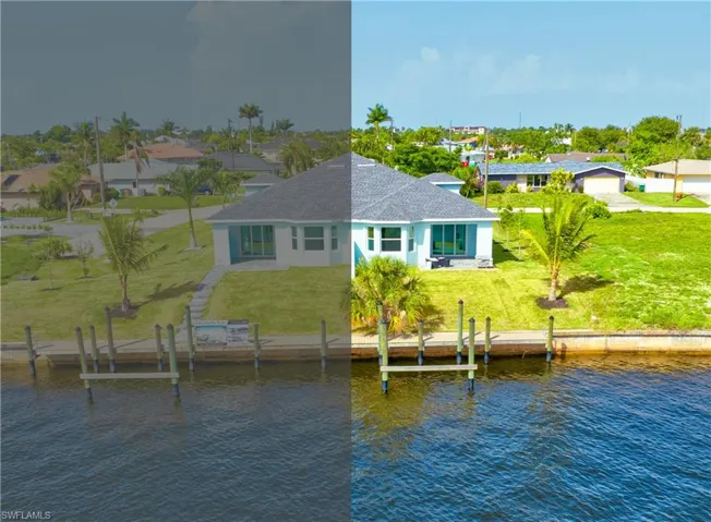 Rear view of house featuring a water view, a lawn, stucco siding, a shingled roof, and a residential view