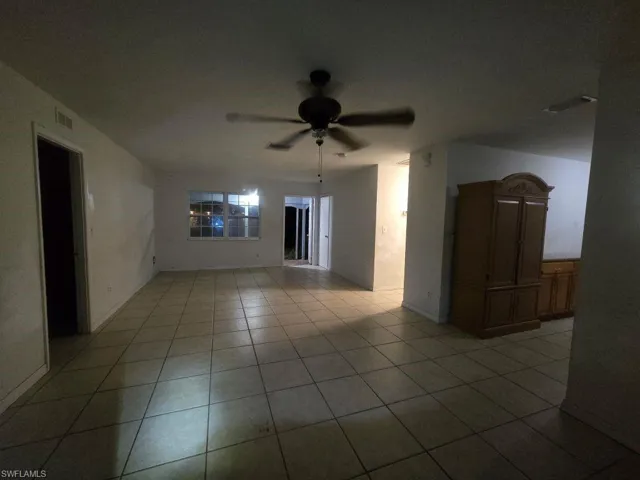 Unfurnished room with ceiling fan and light tile patterned flooring