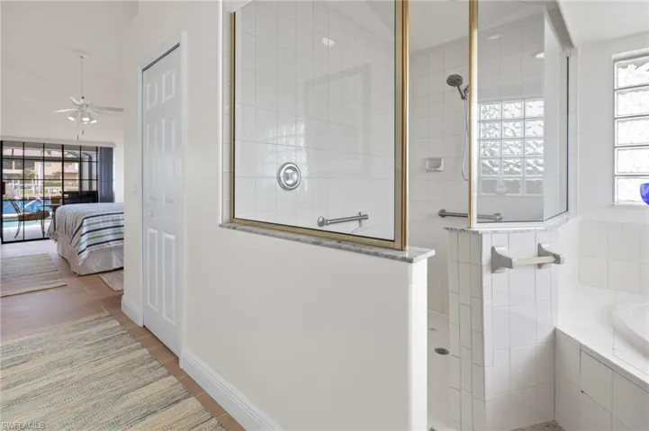 Bathroom with wood-type flooring, separate shower and tub, and plenty of natural light