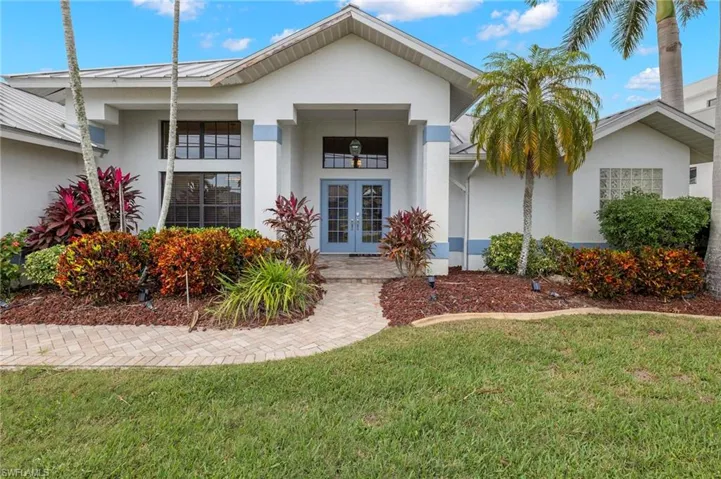View of front of property featuring a front yard and french doors