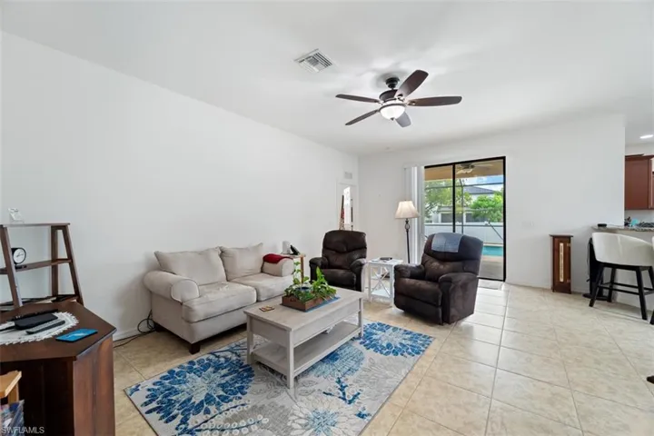 Living area with light tile patterned flooring and a ceiling fan