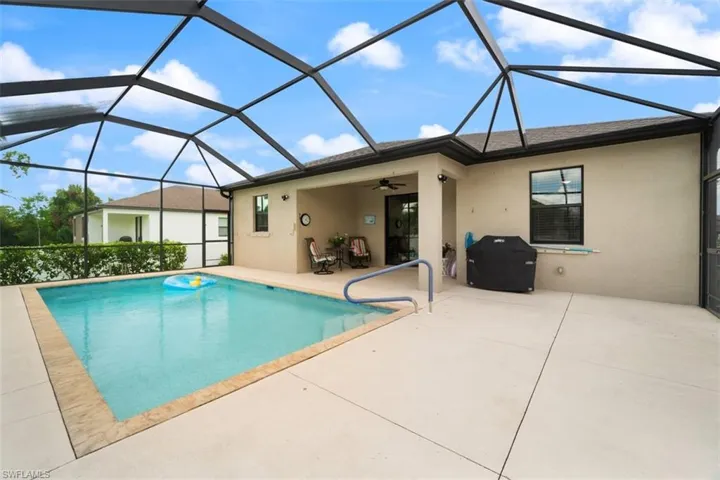 Swimming pool featuring a sunroom, a ceiling fan, a patio, and a lanai