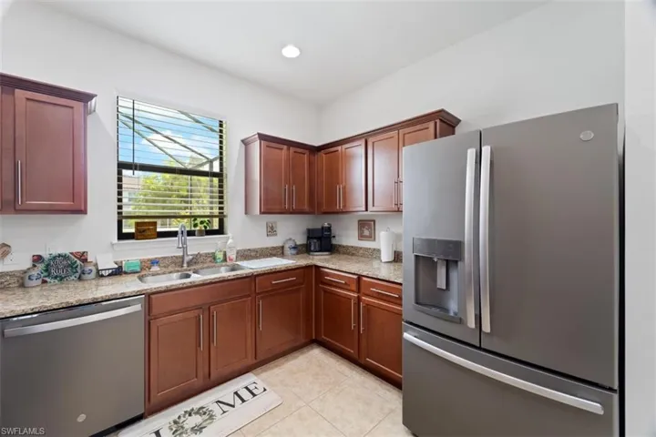 Kitchen with appliances with stainless steel finishes, light stone countertops, recessed lighting, and light tile patterned flooring