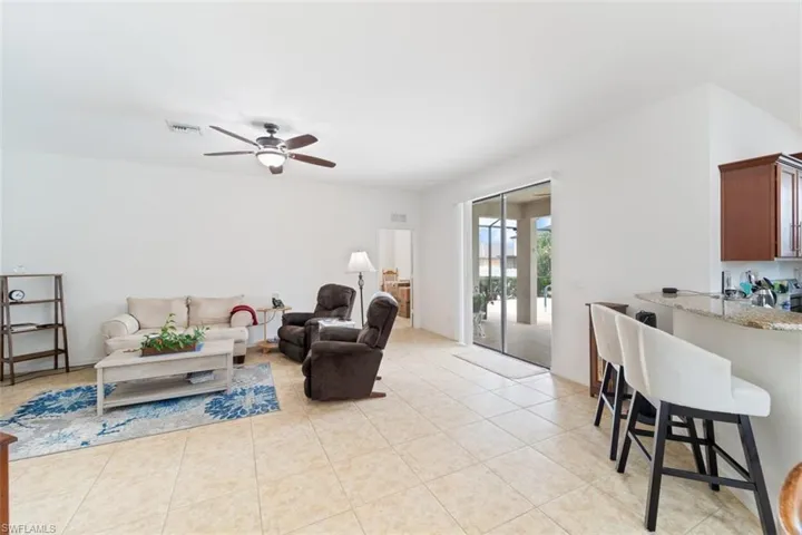 Living room with light tile patterned floors and a ceiling fan