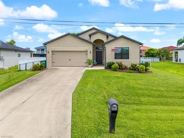 Single story home with stucco siding, concrete driveway, and a garage