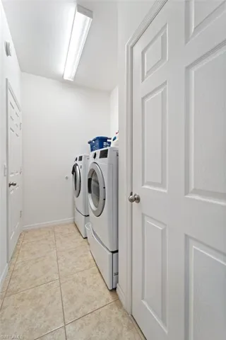Laundry room featuring separate washer and dryer and light tile patterned flooring