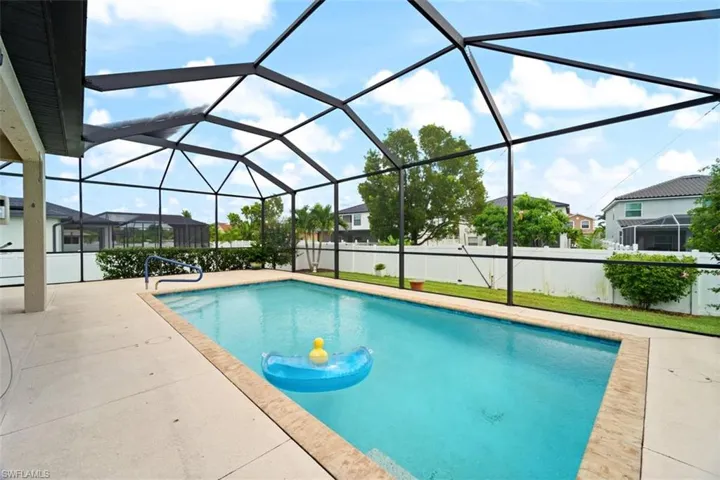 Swimming pool featuring glass enclosure, a sunroom, and a patio