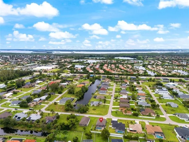 Aerial view of property's location with a large body of water and nearby suburban area
