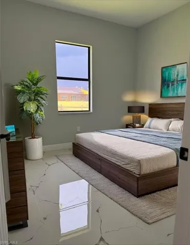 Bedroom featuring marble look tiles and baseboards