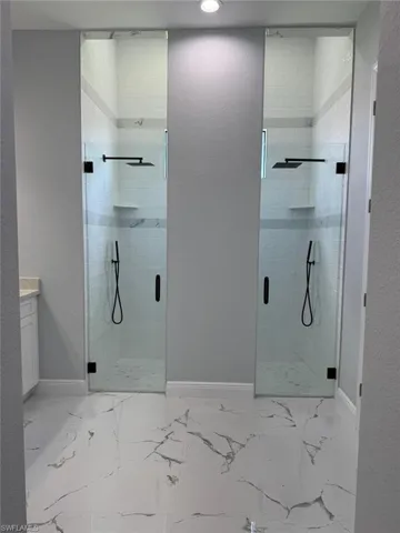 Bathroom featuring a stall shower, baseboards, vanity, recessed lighting, and marble finish flooring