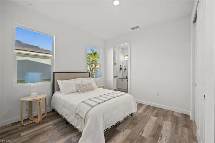 Bedroom featuring a closet, wood-type flooring, and multiple windows